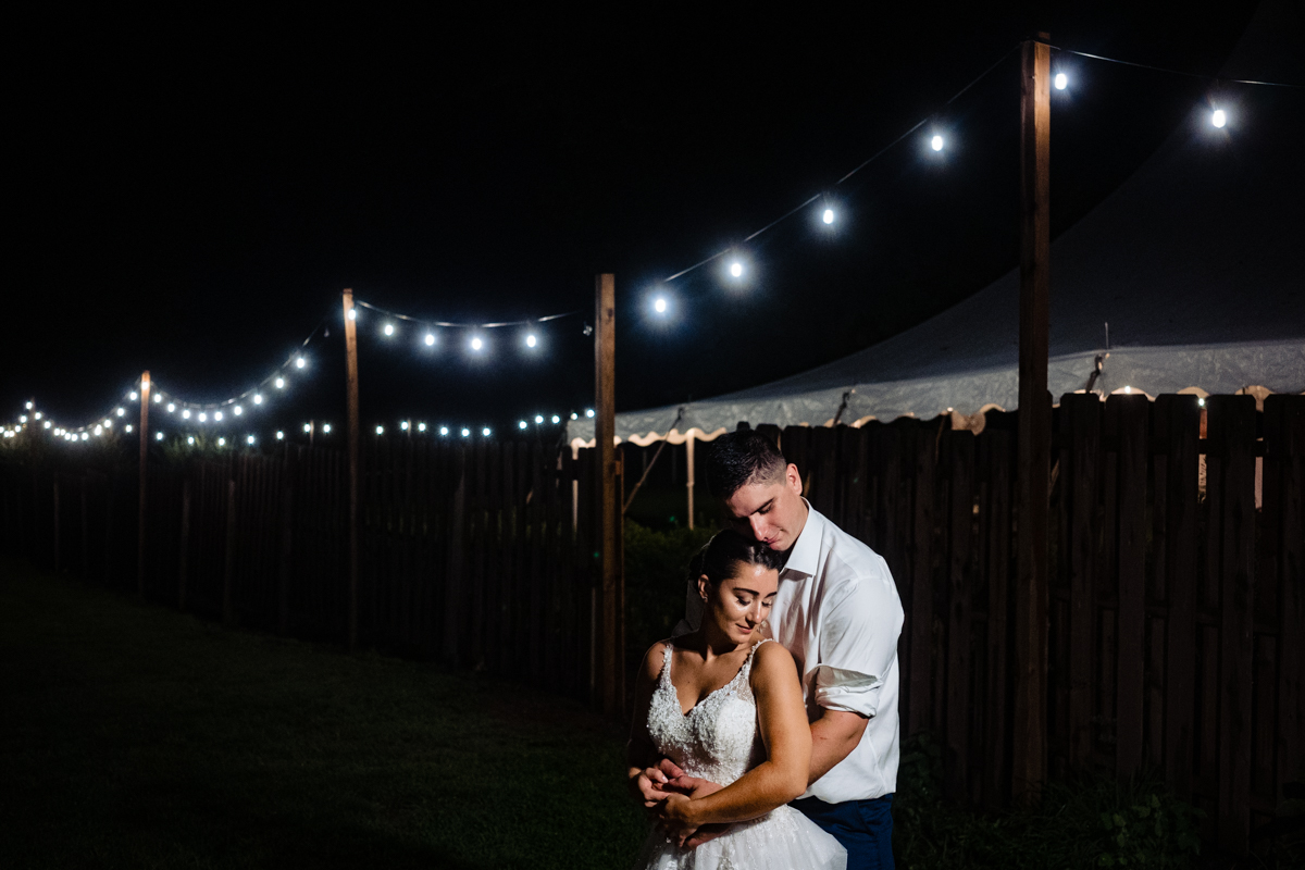 Bride and Groom hugging late at end of their Johnson's Locust Hall Farm wedding.